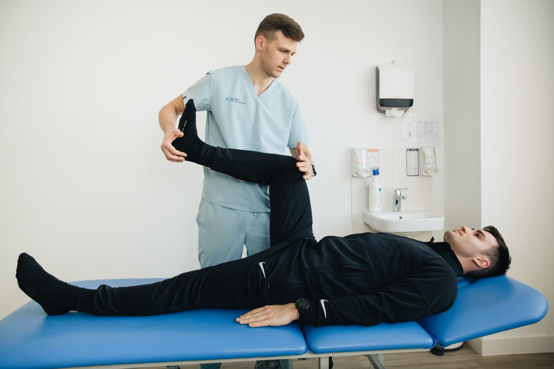 A physical therapist assessing a patient's leg movement
