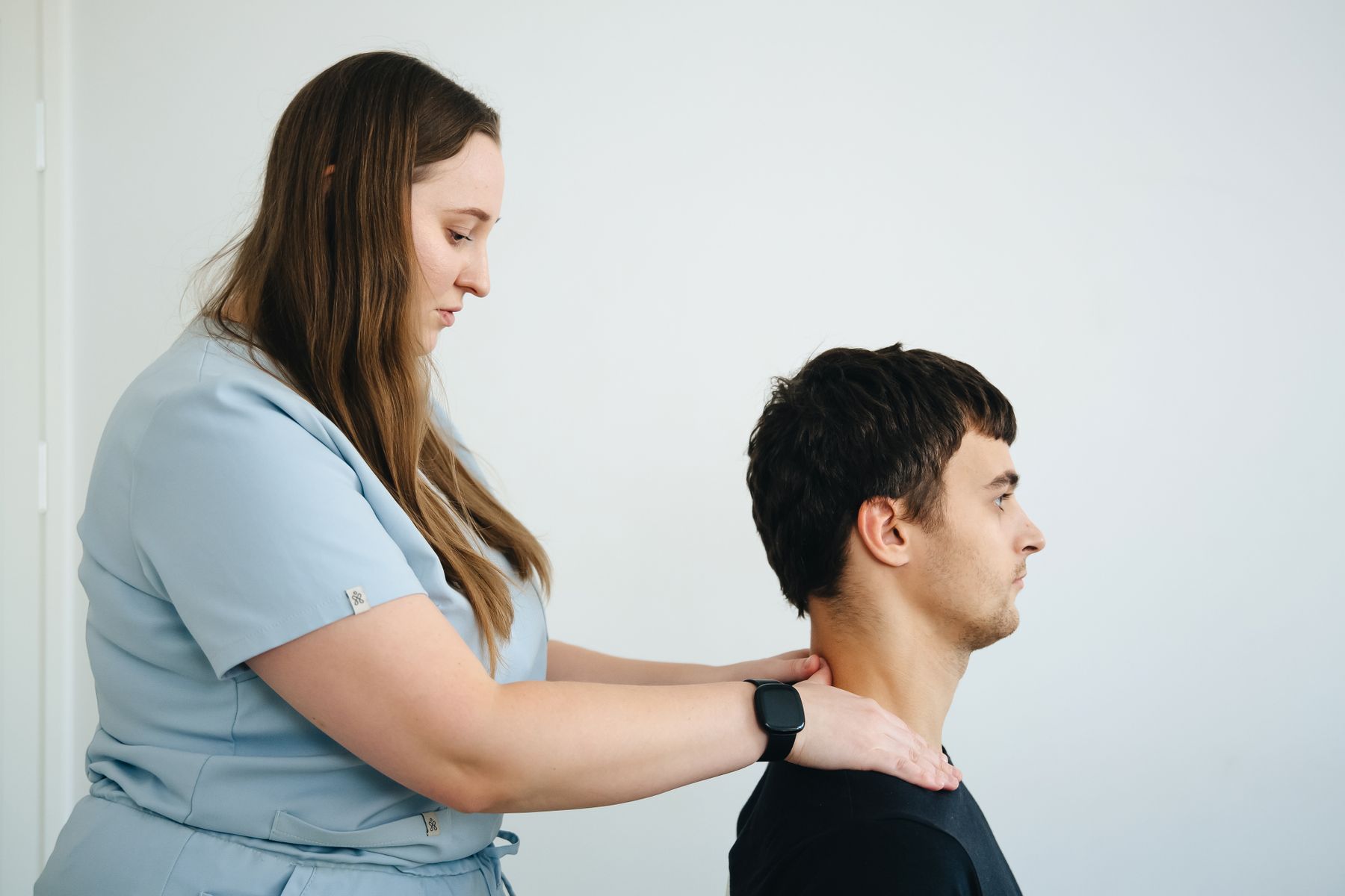 A physiotherapist guiding a patient through a neck movement assessment